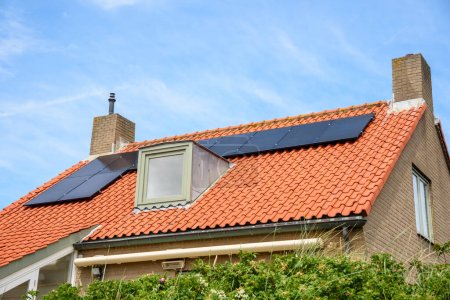 Foto de Paneles solares para la generación de electricidad en el techo de una moderna casa unifamiliar de ladrillo de bajo consumo - Imagen libre de derechos