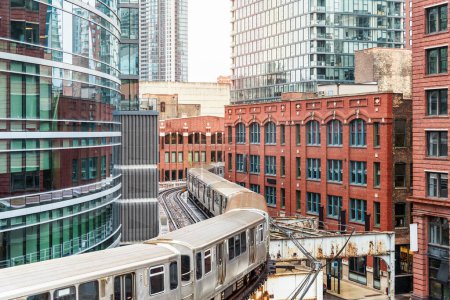 Ein Elektrozug fährt zwischen alten und modernen Gebäuden in der Innenstadt von Chicago hin und her. Illinois, USA.