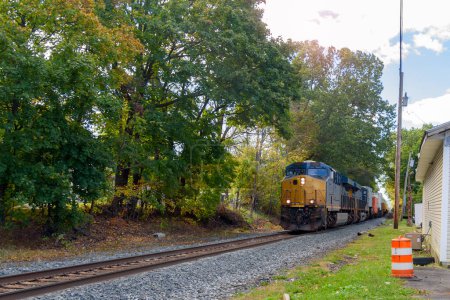Leistungsstarke Diesellokomotive zieht an einem sonnigen Herbstmorgen einen Containerzug. Kingston, NY, USA.