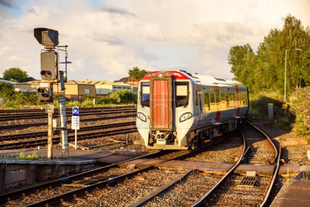 Diesel-Pendlerzug bei der Ankunft in einem Bahnhof bei Sonnenuntergang. Chester, England, Großbritannien.