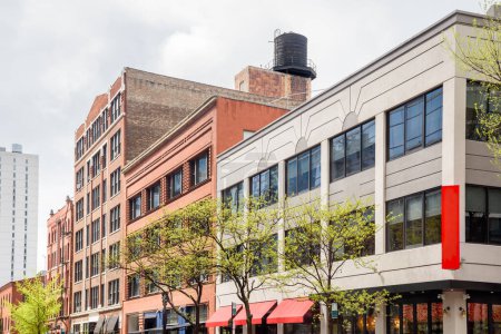 Foto de Edificios antiguos convertidos en lofts con espacio comercial en la planta baja a lo largo de una calle de Chicago en un día nublado de primavera. Illinois, Estados Unidos. - Imagen libre de derechos