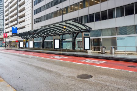 Arrêt de bus du centre-ville déserté avec panneaux d'affichage vierges un jour de pluie. Chicago, IL, États-Unis.