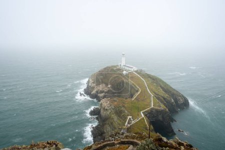 Historic South Stack lighthouse on the top of a small Island off the coast of Wales on a foggy sumnmer day. Holy Island, Anglesey, Wales, UK.