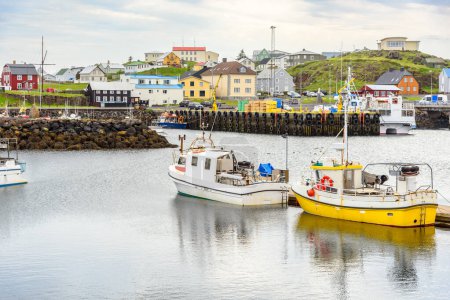 Téléchargez les photos : Bateaux dans le port dans un village de pêcheurs avec des bâtiments colorés en Islande par une journée nuageuse d'été. Stykkishlmur, Islande. - en image libre de droit