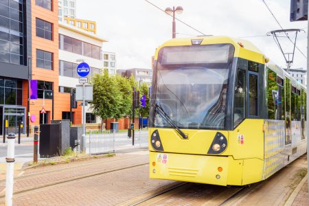 Foto de Tranvía amarillo que corre a lo largo de una calle en un distrito suburbano. Manchester, Inglaterra, Reino Unido. - Imagen libre de derechos
