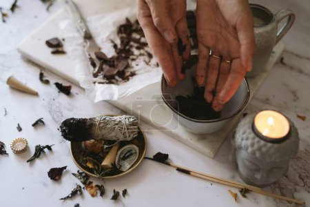 Photo for Female hand in white gloves, black cup of hot tea and dried leaves - Royalty Free Image
