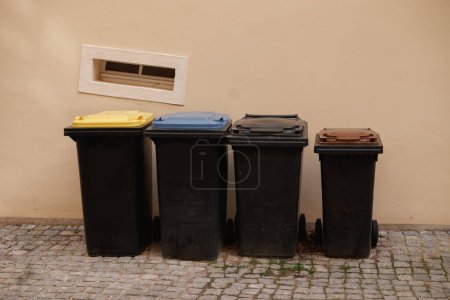 Foto de Different dustbins for waste separation. Recycling in germany. Yellow, blue and brown caps. - Imagen libre de derechos