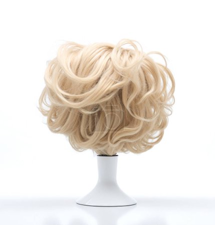 Stylish curly blonde wig displayed on a simple white stand against a clean background