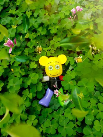 Photo for Clover and yellow toy in the garden with flower background, stock photo - Royalty Free Image