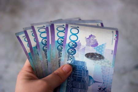 Téléchargez les photos : L'argent kazakh. La vengeance. De la monnaie. Des projets de loi en main. En liquide. Photo de haute qualité - en image libre de droit