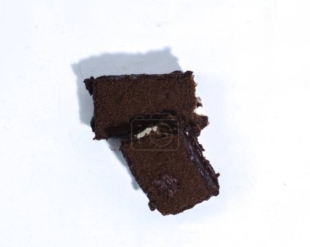 Foto de Deliciosa esponja de capa de chocolate con cobertura de chocolate y relleno de vainilla blanca. en la foto desde el ángulo cerca del fondo blanco. - Imagen libre de derechos
