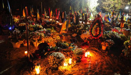 Foto de Lviv, Ucrania, 1 noviembre 2022. Los ucranianos encienden velas mientras visitan las tumbas de los soldados ucranianos que murieron en la guerra con Rusia marcando el Día de Todos los Santos y el Día de Todas las Almas en el Cementerio de Lychakiv en Lviv,. Rusia invadió Ucrania el 24 de febrero - Imagen libre de derechos