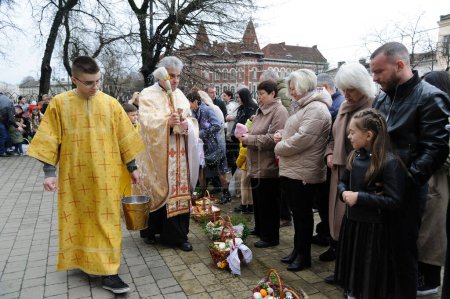 Photo for Lviv, Ukraine 15 April 2023. A Ukrainian priest blesses believers at The Church of Sts. Olha and Elizabeth, Catholic church as they celebrate Easter to mark the resurrection of Jesus Christ from the dead and the foundation of the Christian faith. - Royalty Free Image