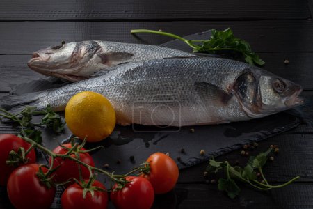 Sea bream or dorado sea fish herbs on dark slate background Top view Mediterranean cuisine. High quality photo