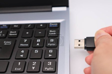Foto de Una persona conectando un USB a una computadora - Imagen libre de derechos