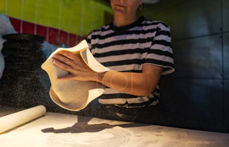 Téléchargez les photos : Plan de détail d'une femme travaillant dans une pizzeria pétrissant la pâte - en image libre de droit