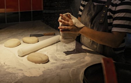Téléchargez les photos : Détail gros plan des mains pétrissant la pâte sur une table de cuisine - en image libre de droit