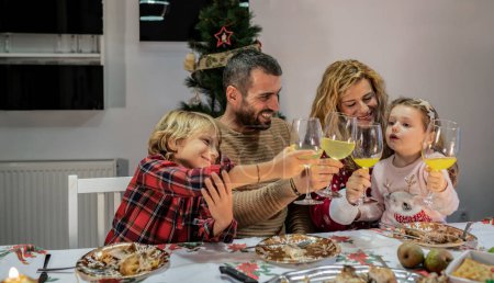 Foto de Familia feliz con niños pequeños tostadas en la cena de Navidad, feliz celebrar el año nuevo - Imagen libre de derechos