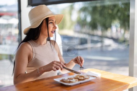 Photo for Young adult woman enjoying her vacation eating some pancakes mall - Royalty Free Image