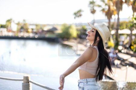 Photo for Young woman in hat happy with open arms and smiling - Royalty Free Image