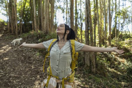 Téléchargez les photos : Jolie femme trekking avec un sac à dos s'arrête pour respirer l'air frais - en image libre de droit