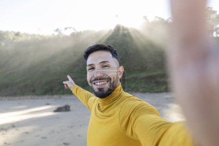 Photo for Handsome man taking selfie on the beach Spain - Happy tourist having fun walking outside on summer vacation - European travel, vacation and landmarks concept - Royalty Free Image