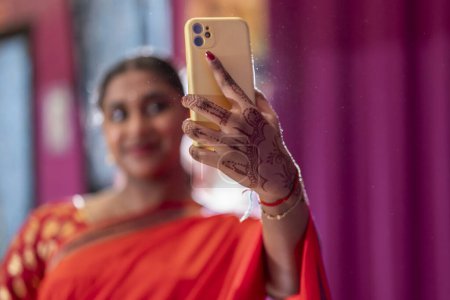 Téléchargez les photos : Gros plan de la jeune femme indienne prend un selfie après ses cours de danse bollywood. l'accent est mis sur le téléphone - en image libre de droit