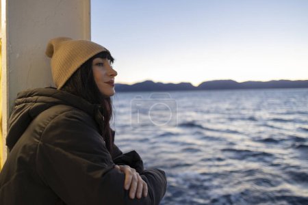 Photo for Tourist woman leaning out of the window of a boat watching the sunset - Royalty Free Image