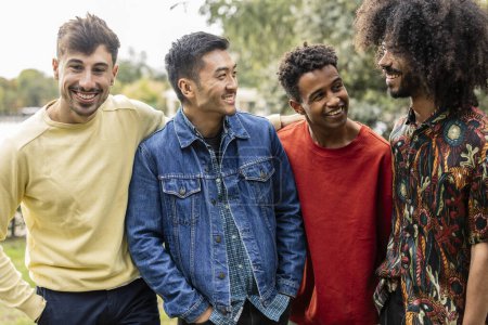 Téléchargez les photos : Groupe de jeunes adultes multiraciaux amis masculins parler et rire les uns avec les autres - en image libre de droit