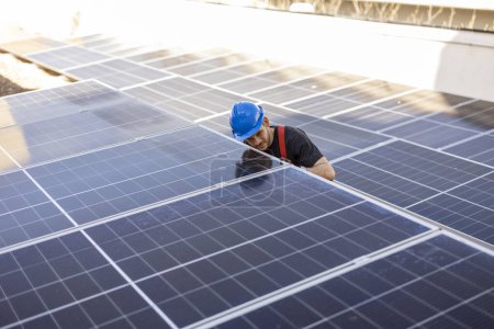 Photo for Engineer between solar panels assembling and installing safely - Royalty Free Image