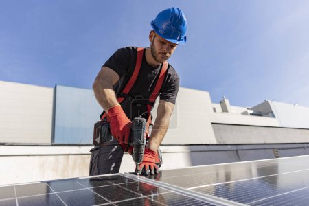 Téléchargez les photos : Ingénieur expert en panneaux solaires faisant une installation sur le toit - en image libre de droit