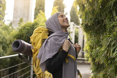 Photo for Toothy smile of veiled muslim woman exploring new places with her backpack - Royalty Free Image