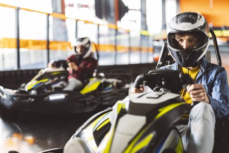 Foto de Campeonato de carreras de karts superando rivales en el circuito de carretera adolescente sosteniendo el volante - Imagen libre de derechos