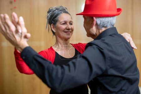 Téléchargez les photos : Gros plan femme senior danse tenant la main avec son partenaire dans la classe de danse latine classique - en image libre de droit