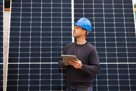 Photo for Engineer checking solar panels for installation with his graphics tablet - Royalty Free Image