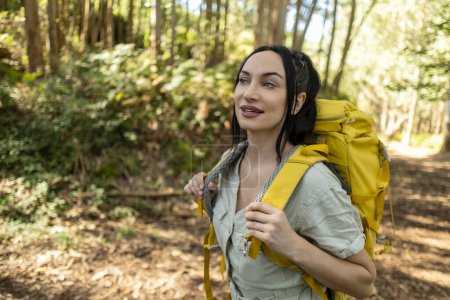 Photo for Portrait of a beautiful female hiker smiling holding her backpack - Royalty Free Image