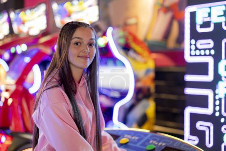 Porträt einer jungen Frau, die in einem Spielzimmer mit Neonlicht in die Kamera blickt