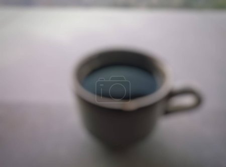 Paisaje. Bokeh, primer plano de un vaso de café negro en una mesa de cerámica. Una taza pequeña con un fondo natural bokeh.
