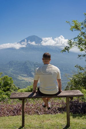 Photo for Man looking at Agung volcano in Indonesia, Bali island , beautiful landscape of volcano. - Royalty Free Image