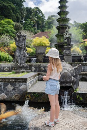 Foto de Niña turista en Taman Tirtagangga, Palacio del Agua, Parque Acuático, Bali Indonesia. Viajar con concepto de niños. - Imagen libre de derechos