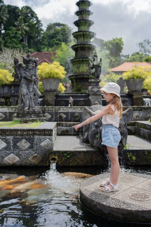 Foto de Niña turista en Taman Tirtagangga, Palacio del Agua, Parque Acuático, Bali Indonesia. Viajar con concepto de niños. - Imagen libre de derechos