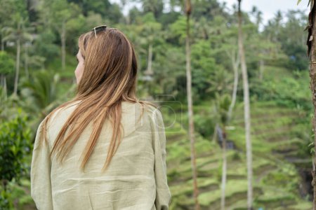 Téléchargez les photos : Une vue arrière de la femme profitant de la vue sur les rizières vertes. Ubud. Bali, Indonésie. Concept de voyage. - en image libre de droit