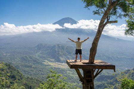 Foto de Hombre viajero disfrutar de sus vacaciones en la isla de Bali, de pie en el mirador con el volcán Agung - Imagen libre de derechos