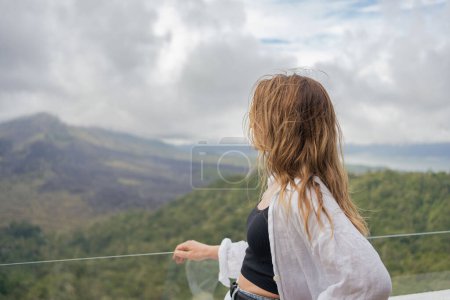 Téléchargez les photos : Voyageur femme se tient sur le point de vue dans les montagnes, Bali point de repère volcan Agung vue. - en image libre de droit