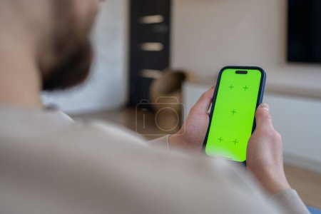 Photo for Man using smartphone with chroma key screen at home - Royalty Free Image