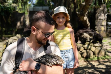 Téléchargez les photos : Personnes touchant lézard moniteur dans zoo contact, Bali, Indonésie. - en image libre de droit