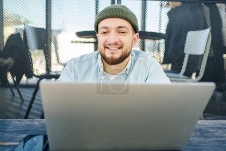 Photo for Portrait of cheerful blogger with cellphone and laptop technology enjoying freelance lifestyle, happy hipster guy using mobile phone and netbook in cafe. - Royalty Free Image