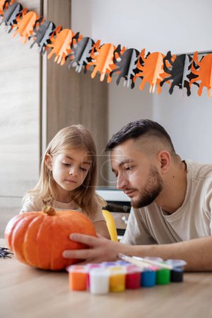 Photo for Happy family father and daughter making Halloween home decorations together - Royalty Free Image