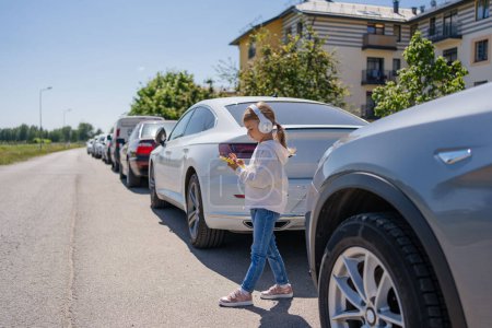 Photo for Child is watching the phone on the road, crossing or using a mobile phone for a long time hurts her eyes and has an aggressive atmosphere - Royalty Free Image