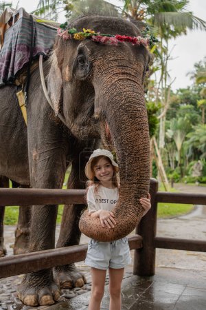 Téléchargez les photos : Éléphants jouer avec un enfant fille .hugging le tronc - en image libre de droit